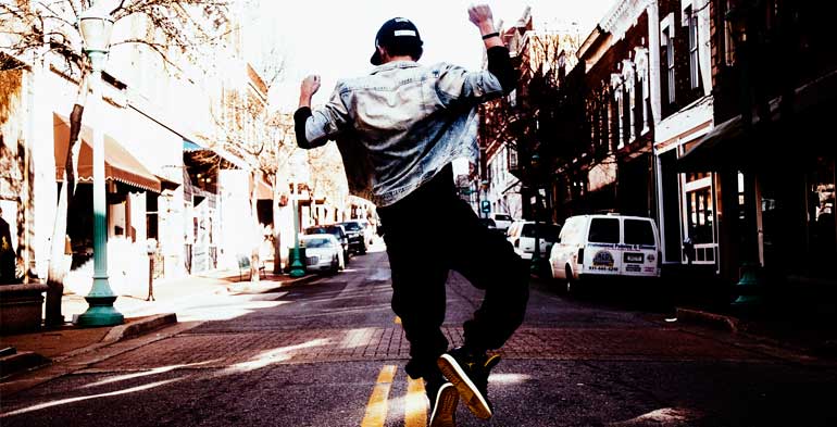 o dançarino de hip hop está no meio da rua, fazendo alguns passos